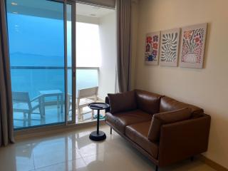 Modern living room with ocean view, leather sofa, and balcony access