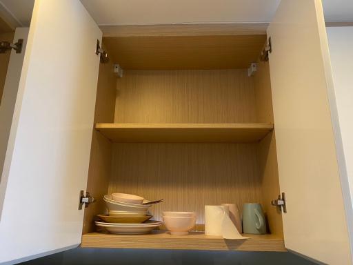 Open kitchen cabinet with shelves showcasing dishware