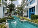 Swimming pool area surrounded by lush greenery and modern buildings