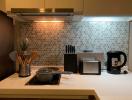 Modern kitchen with stainless steel appliances and hexagonal backsplash