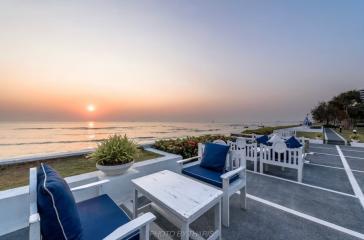 Cozy outdoor seating area with ocean view at sunset