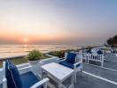 Cozy outdoor seating area with ocean view at sunset