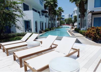 Poolside lounge area with sunbeds in a modern residential complex