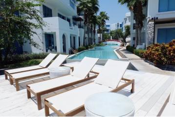 Poolside lounge area with sunbeds in a modern residential complex