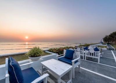 Serene seaside outdoor seating area with sunset view