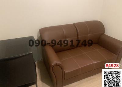 Cozy living room with a brown leather sofa and a black side table