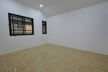 Spacious and well-lit empty bedroom with tiled flooring and a large window