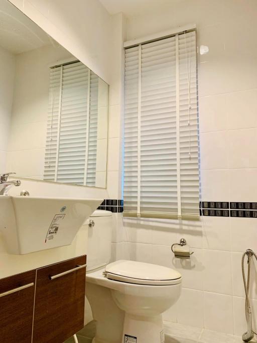 Modern bathroom with white fixtures and wooden vanity