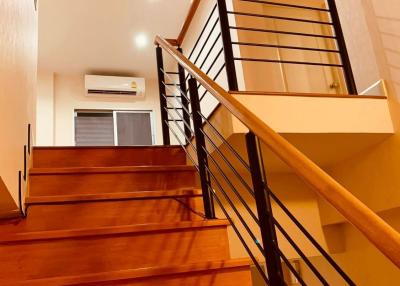 Modern wooden staircase with metal balusters and warm lighting