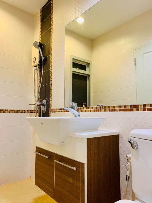 Modern bathroom interior with wall-mounted sink, toilet, and shower