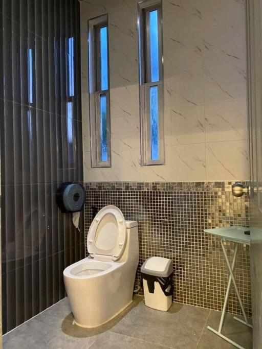 Modern bathroom with mosaic tiles and tall windows