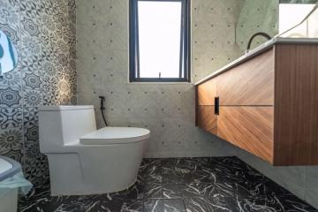 Modern bathroom with patterned tiles and wooden vanity