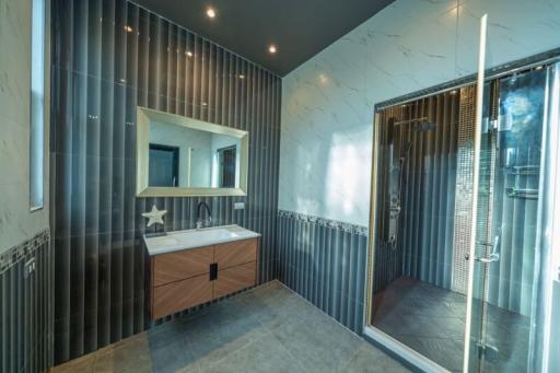 Spacious modern bathroom with glass shower and vanity mirror