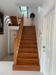 Wooden staircase with white walls in a bright home interior