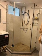 Modern bathroom with glass shower enclosure and beige tiles