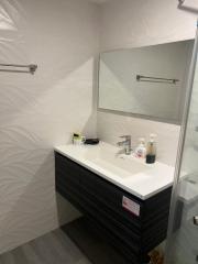 Modern bathroom interior with a vanity cabinet and large mirror