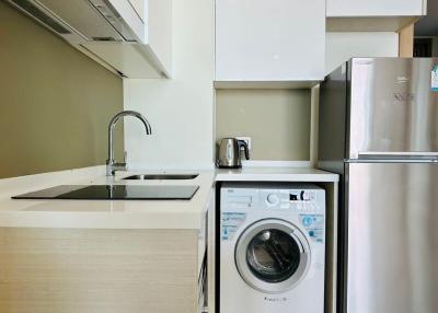 Modern kitchen with built-in appliances and laundry machine