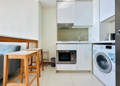 Compact modern kitchen with integrated appliances and ceramic tiling