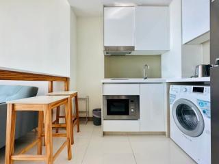 Compact modern kitchen with integrated appliances and ceramic tiling