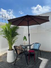 Cozy outdoor patio with umbrella, seating area and decorative plants