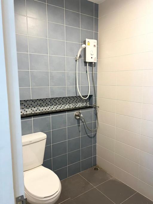 Modern bathroom with wall-mounted shower head and blue tiles