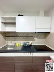 Compact modern kitchen with white cabinetry and stainless steel appliances