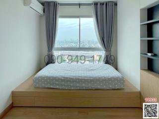 Cozy bedroom with a large window and city view