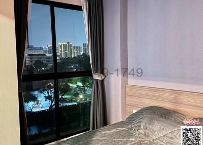 Cozy bedroom with a large window and city view at night