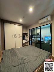 Cozy bedroom interior with a large bed, wardrobe, air conditioning, and balcony access