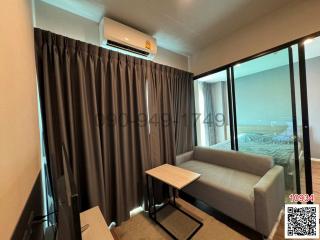 Modern living room with sectional sofa, and a view to the adjacent bedroom