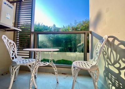 Cozy balcony with white patio furniture and a view of the garden