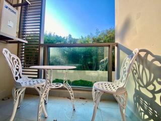 Cozy balcony with white patio furniture and a view of the garden