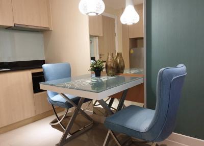 Modern dining area with table, chairs, and kitchen in the background