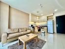 Spacious and well-lit combined living room and open kitchen with modern appliances and furnishings