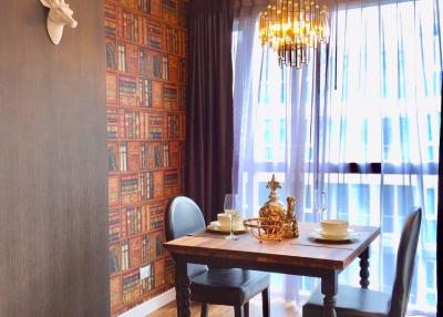 Elegant dining room with a wooden table, stylish chandelier, and decorative wall