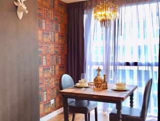 Elegant dining room with a wooden table, stylish chandelier, and decorative wall