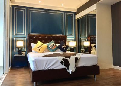 Elegant bedroom with blue walls and dark wood flooring