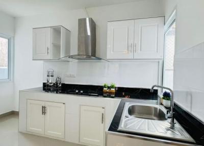 Modern kitchen with white cabinetry and black countertops