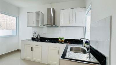 Modern kitchen with white cabinetry and black countertops