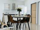 Modern white themed kitchen with dining table set and decorative Eiffel tower sculpture