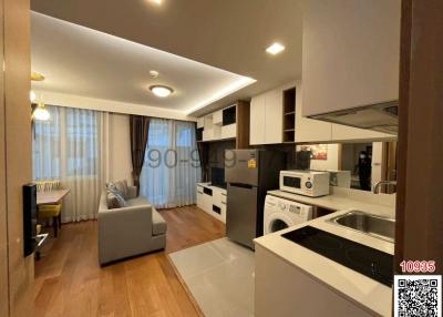 Modern open-plan living room with adjoining kitchen, featuring clean lines and integrated appliances