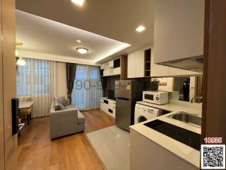 Modern open-plan living room with adjoining kitchen, featuring clean lines and integrated appliances