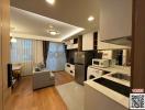 Modern open-plan living room with adjoining kitchen, featuring clean lines and integrated appliances