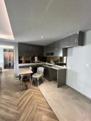 Modern kitchen with gray cabinetry and herringbone wood flooring