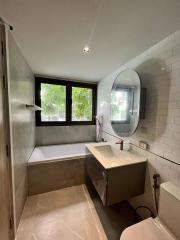 Modern bathroom with bathtub and oval mirror