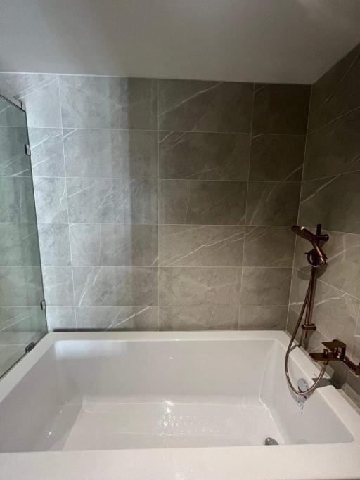 Modern bathroom with tiled walls and bathtub