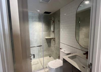Modern bathroom interior with a walk-in shower, a toilet, and a sink