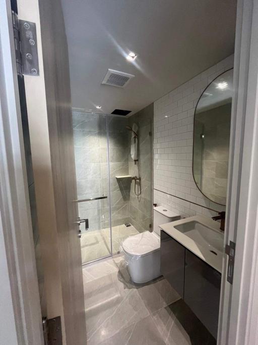 Modern bathroom interior with a walk-in shower, a toilet, and a sink