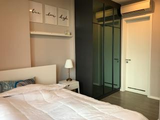 Cozy modern bedroom with air conditioning and glass sliding wardrobe doors