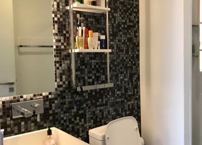 Modern bathroom with wall-mounted shelves and mosaic tiles